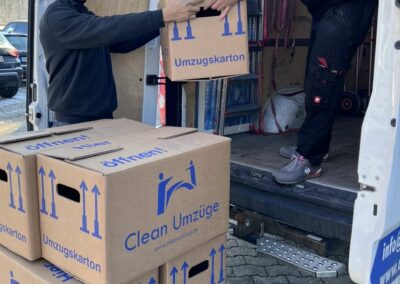 Teammitglieder von Clean-Umzüge Nürnberg beim Verladen von gepackten Umzugskartons