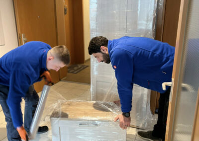 Umzugs-Fachkräfte vom Umzugsunternehmen Clean-Umzüge Nürnberg beim Verpacken von Möbelstücken